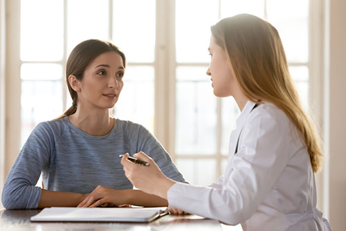 Young woman discussing problems with psychiatrist